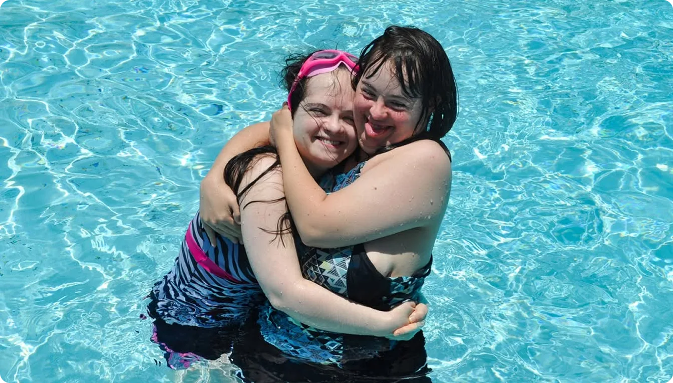 Two girls hugging in a pool