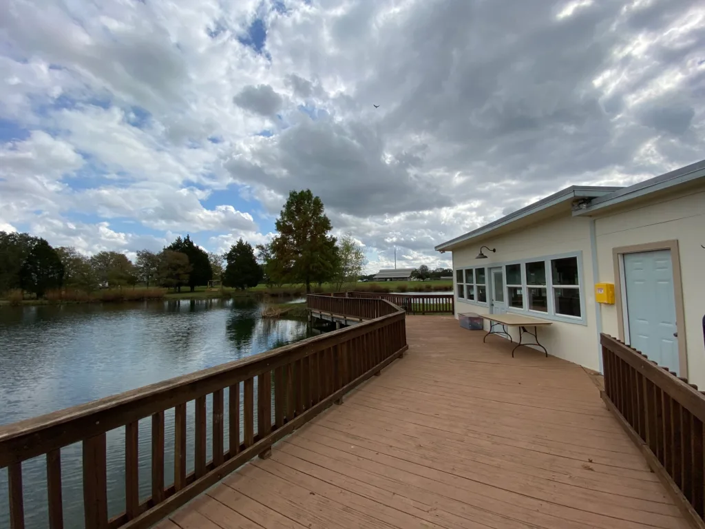 Catch and release fishing pond with large dock and building nearby with bathrooms and meeting space.
